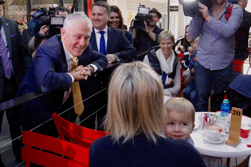 Malcolm Turnbull on the 2016 campaign trail looks at a woman and a baby