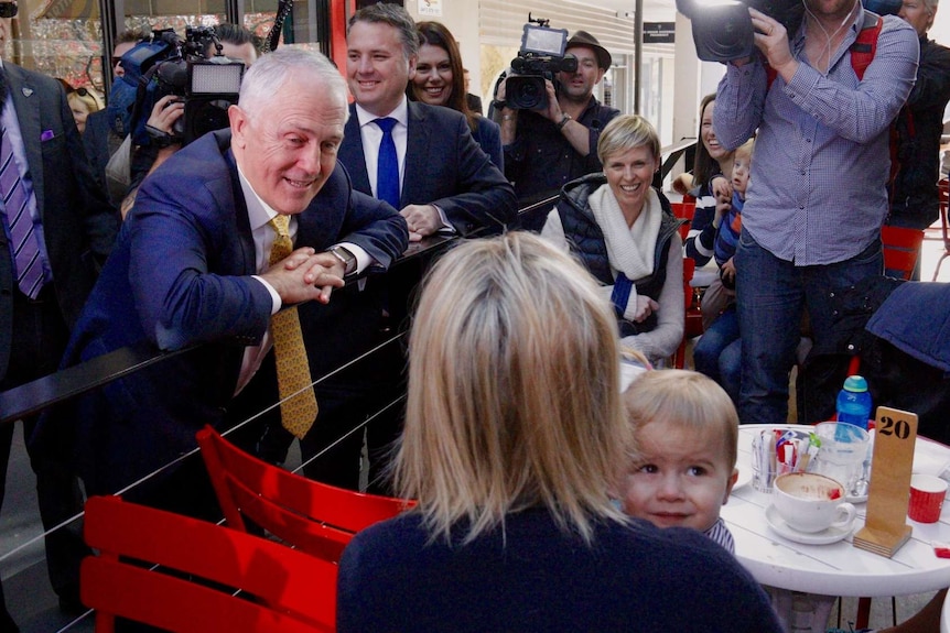 Malcolm Turnbull on the 2016 campaign trail looks at a woman and a baby