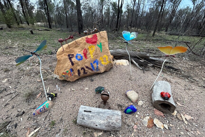 A collection of colourful rocks and items in memory of Alan Dare at the site where he was killed.