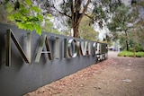 A large concrete sign with letters saying National Gallery of Australia.