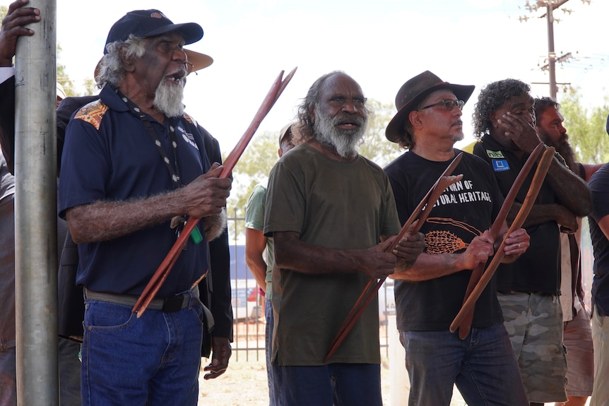 Aboriginal men stand together holding spears