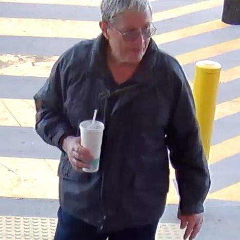 An image taken from CCTV footage showing Ian Collett walking to the entrance of a convenience store holding a takeaway drink.