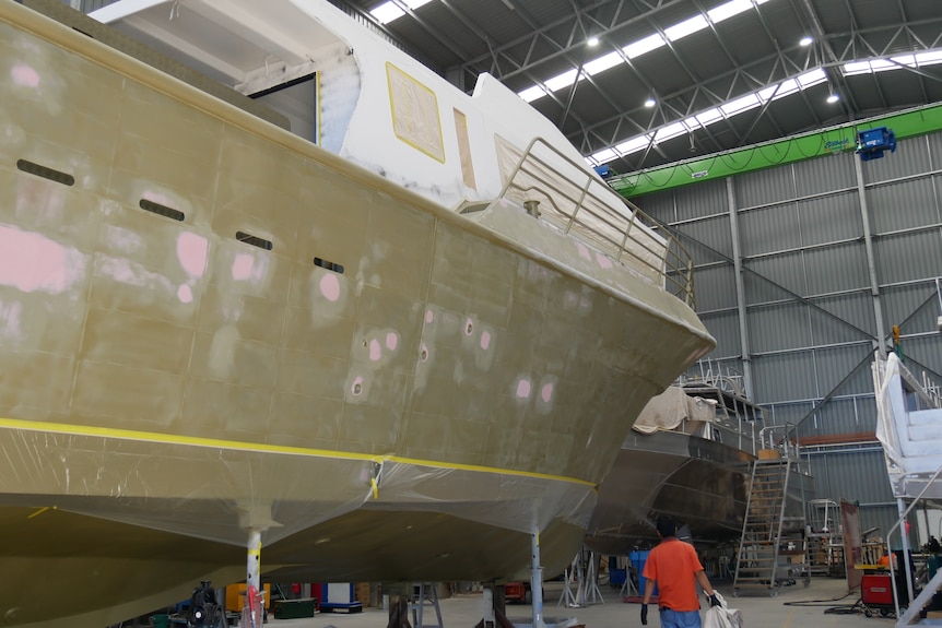A boat being built inside a warehouse. 