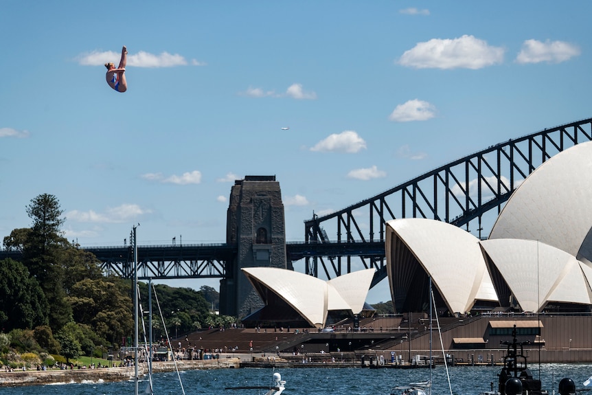 Molly Carson dives in pike position in front of the Opera House