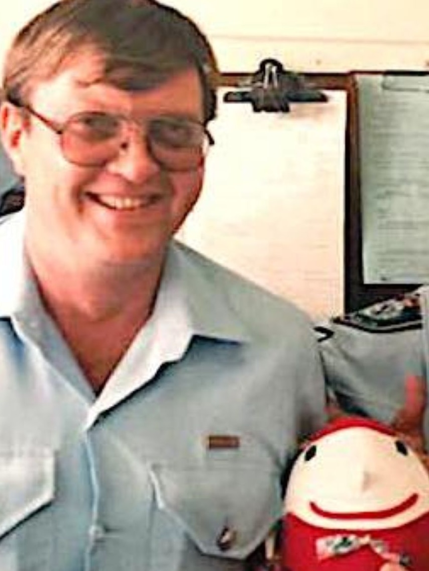 Portrait photo of a thirtyish man in uniform, smiling and holding a Humpty Dumpty toy