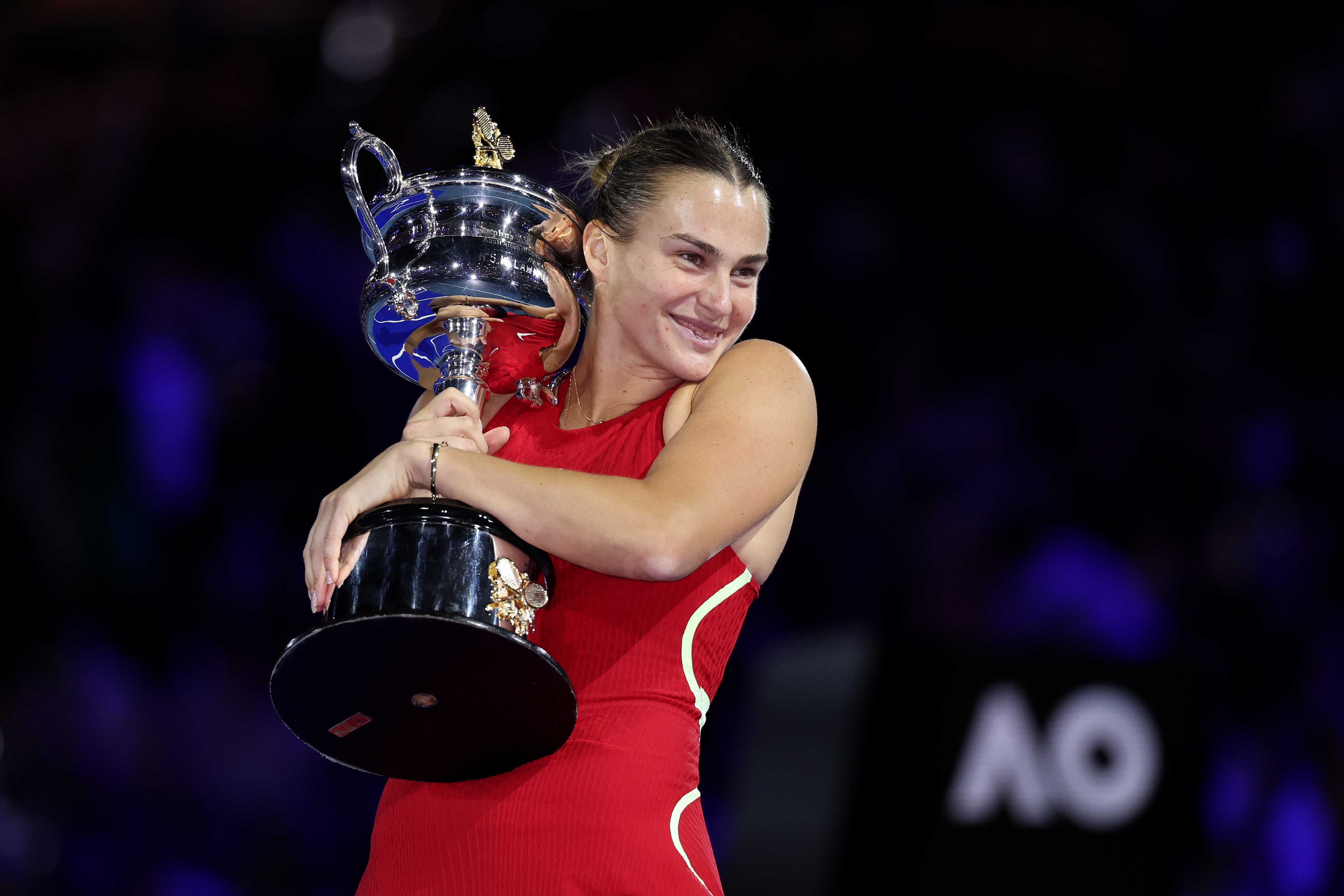 Aryna Sabalenka poses with the Daphne Akhurst Memorial Cup following her 2024 Australian Open victory.