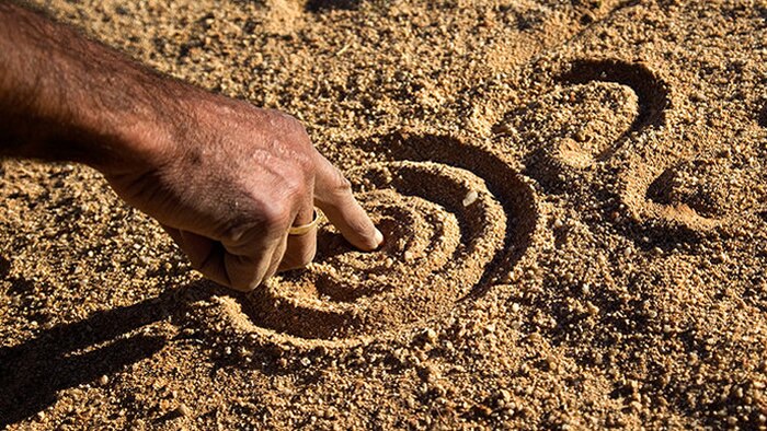 An image of a waterhole drawn in the sand