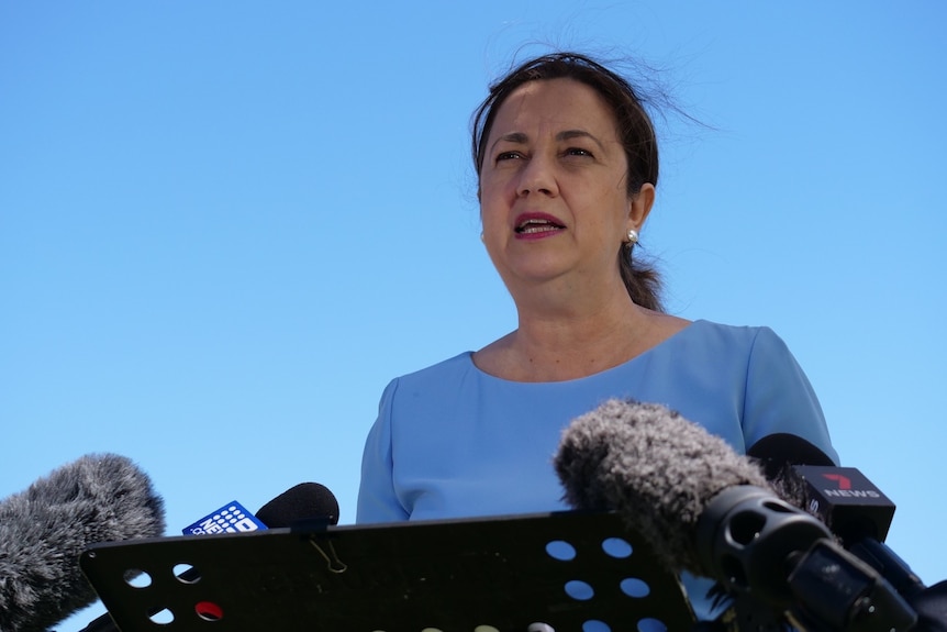 Queensland Premier Annastacia Palaszczuk stands in front of a blue sky