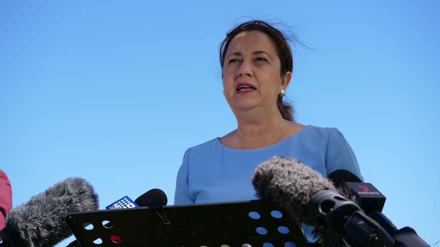 Queensland Premier Annastacia Palaszczuk stands in front of a blue sky