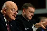 James Clapper sits down with his arm in front at Senate Armed Services Committee hearing