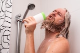 bearded man in the shower singing into shampoo bottle
