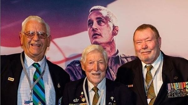 Three elderly men in sports coats with military ribbons