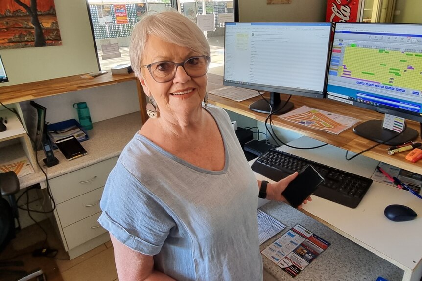 Anne Thomas from Kimberley Entrance Caravan Park in Derby standing at a desk, April 2022. 