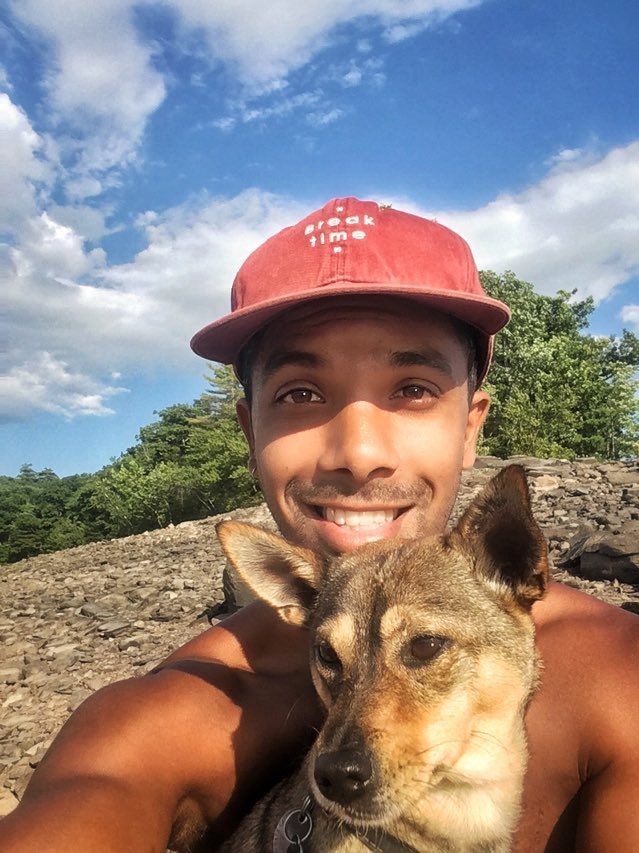 Selfie of Andre Rangiah with a dog on a sunny day.