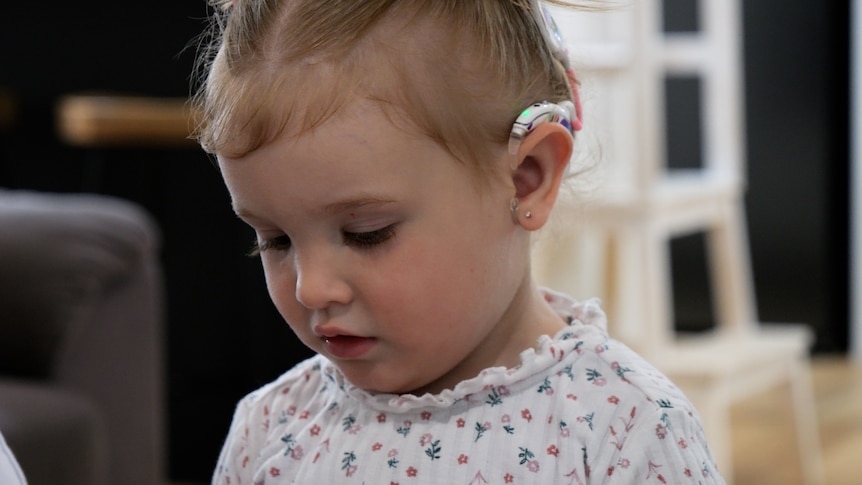Headshot of toddler Azaria, showing her hearing aid.