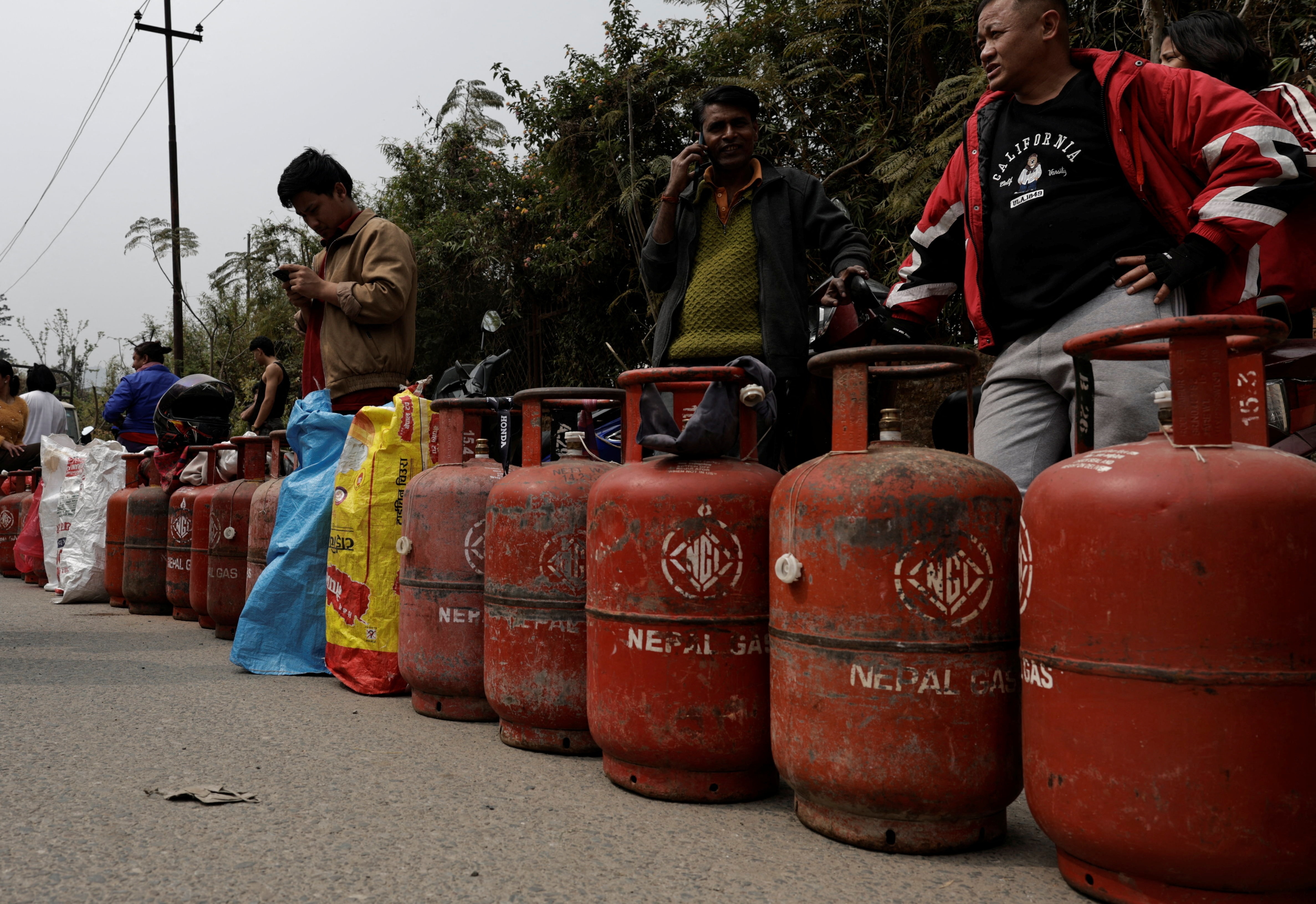 Gaz tüpleriyle kuyrukta bekleyen insanlar.
