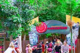 Visitors to Dreamworld theme park walking in and out of the entrance to the Indigenous stories attraction