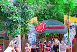 Visitors to Dreamworld theme park walking in and out of the entrance to the Indigenous stories attraction