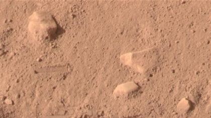 Patches of white are revealed under Martian dust on June 20, 2008. NASA says the photograph, taken by the Mars Phoenix Lander, proves the existence of ice on the red planet.