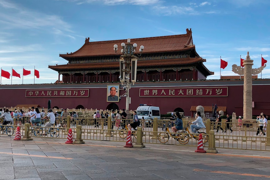 Residents past by a a police van parked in front of Tiananmen Gate in Beijing.