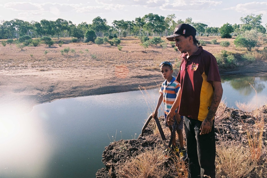 Two Carter family members stand beside a creek