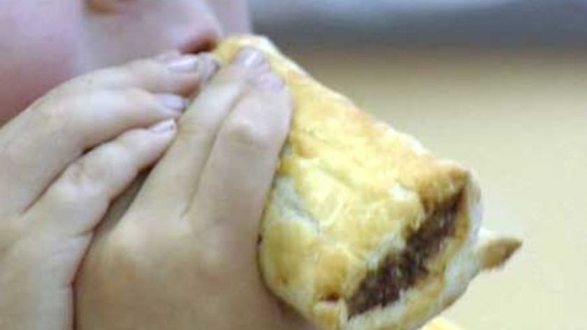 Child eats a sausage roll.