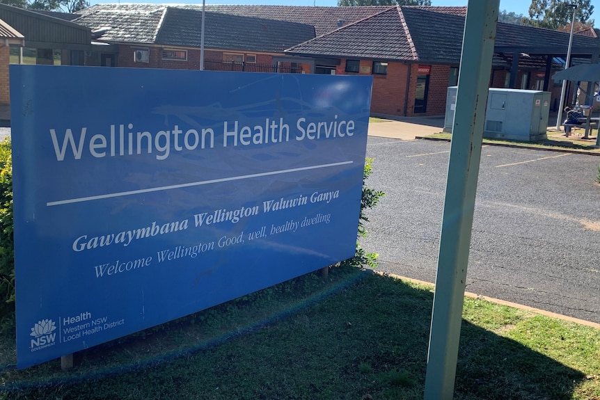 Exterior of hospital with signage in the foreground.