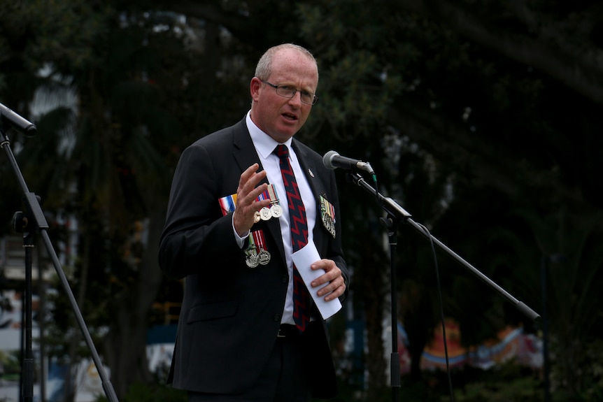 Mr Anderson speaks into a microphone.