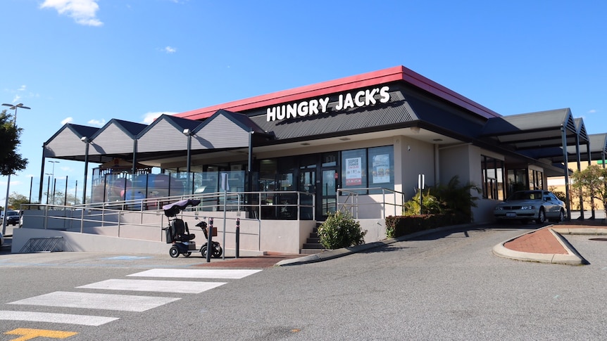 A mobility scooter sits abandoned outside Hungry Jack's, where a body was reportedly found after sitting there for three days.