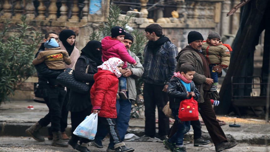 People carry their belongings as they flee deeper into the remaining rebel-held areas of Aleppo, Syria, 13 December 2016.