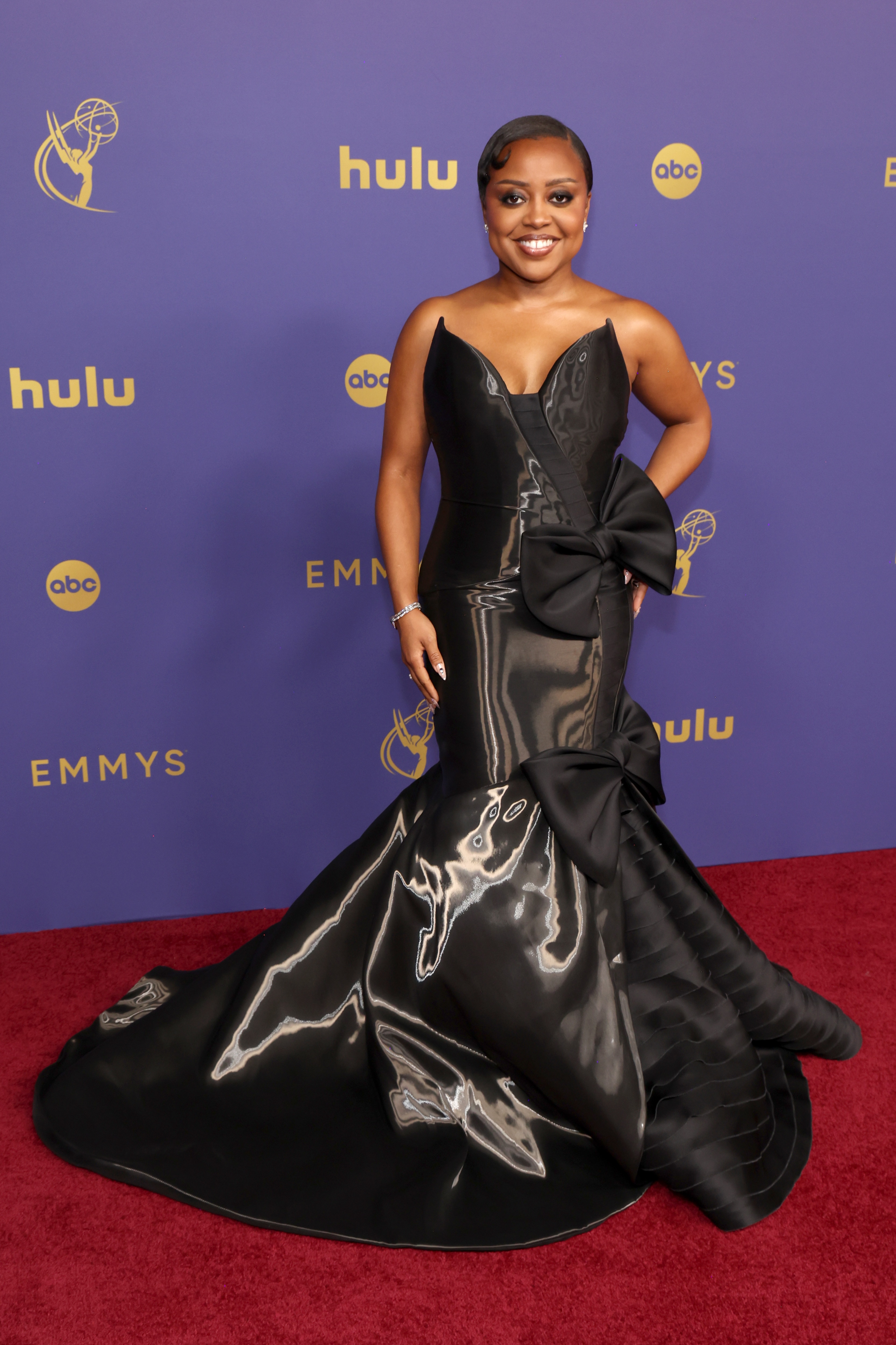 Quinta Brunson wearing a long stapless balck gown with bow-like neckline and a mermaid skirt