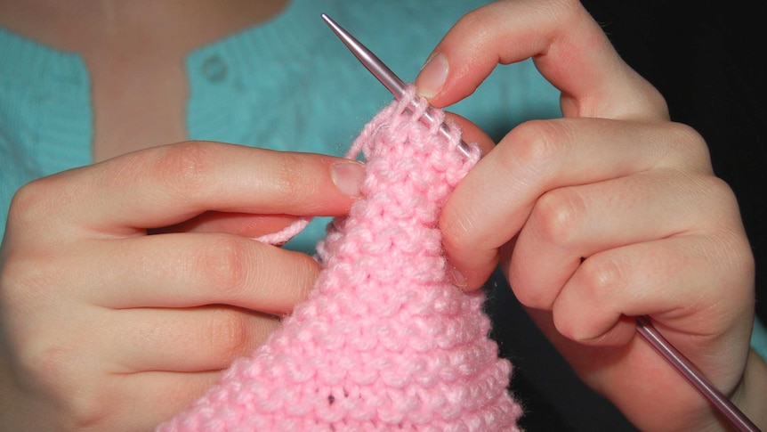 A woman knits.