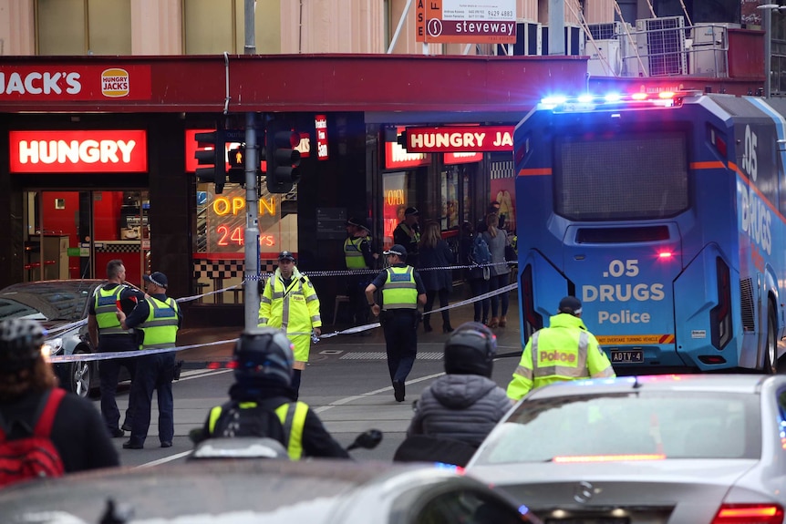 A drug testing bus and police tape is used to block Bourke Street.