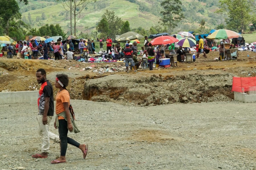 A couple in PNG walking down a road together