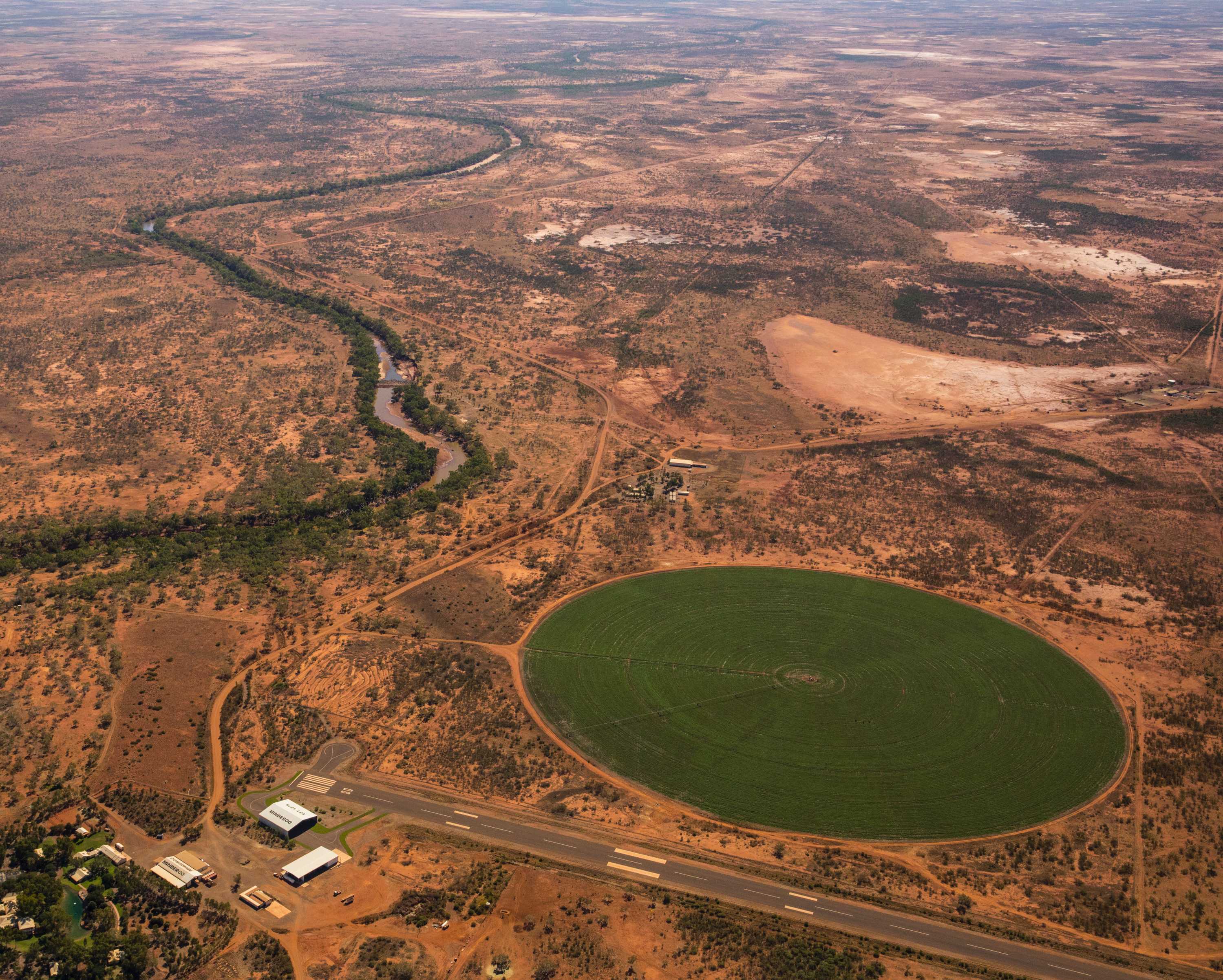 An aerial shot of red earth with a deep green circle of irrigated land