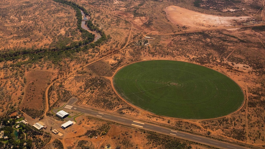 An aerial shot of red earth with a deep green circle of irrigated land