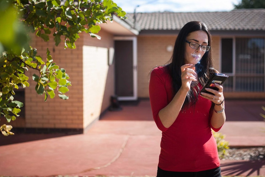 Zandalee, a skimpy from Perth, smokes a cigarette in Kalgoorlie, WA.