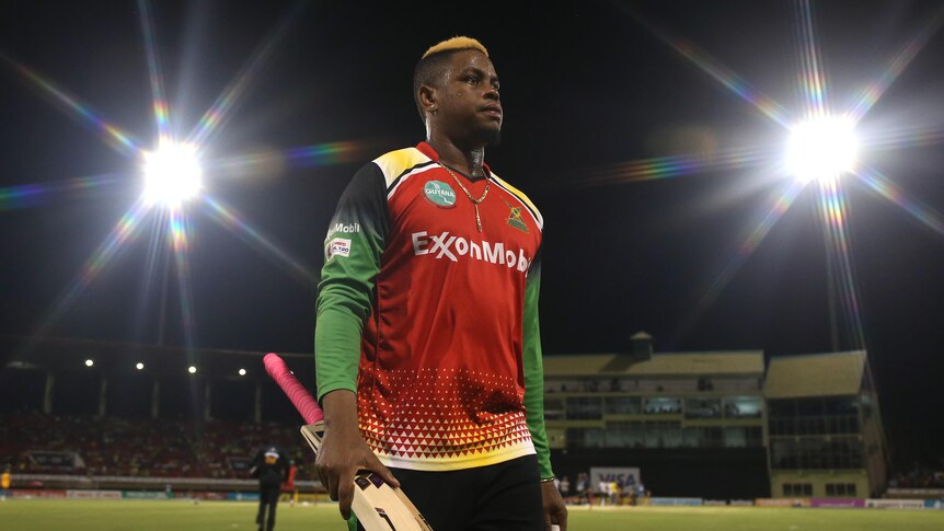 Shimron Hetmeyer walks off the field under lights after a Caribbean Premier League game.