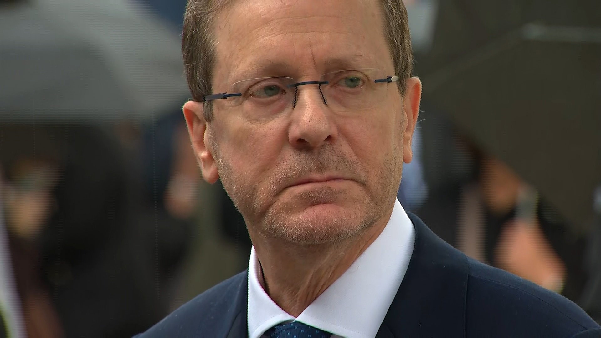 Isaac Herzog participa en una rueda de prensa vestido con chaqueta y gafas pequeñas.