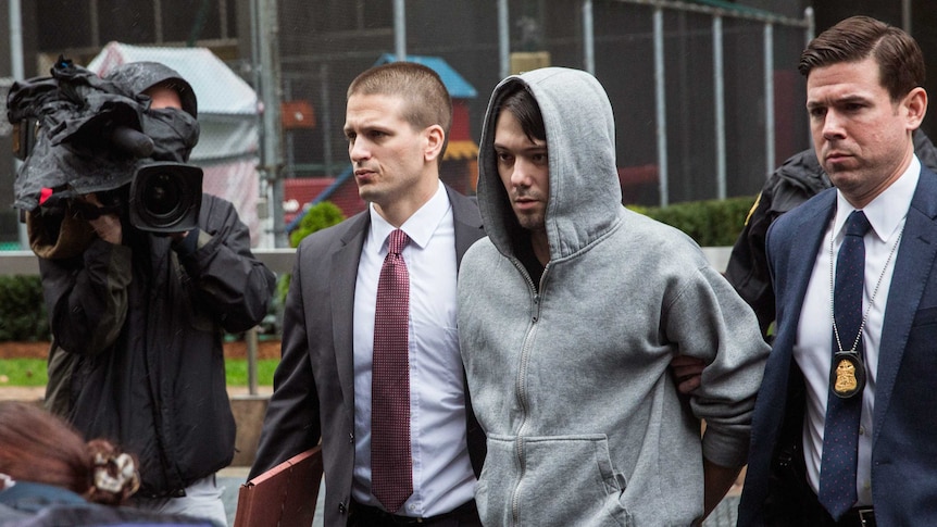 Turing Pharmaceutical CEO Martin Shkreli escorted by guards.