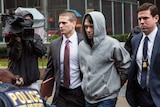 Turing Pharmaceutical CEO Martin Shkreli escorted by guards.
