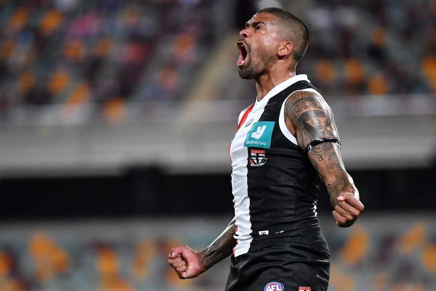 A St Kilda AFL player screams out as he looks towards the sky while celebrating a goal against GWS.