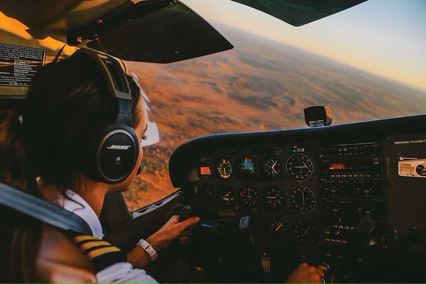 A female pilot flying over Uluru.