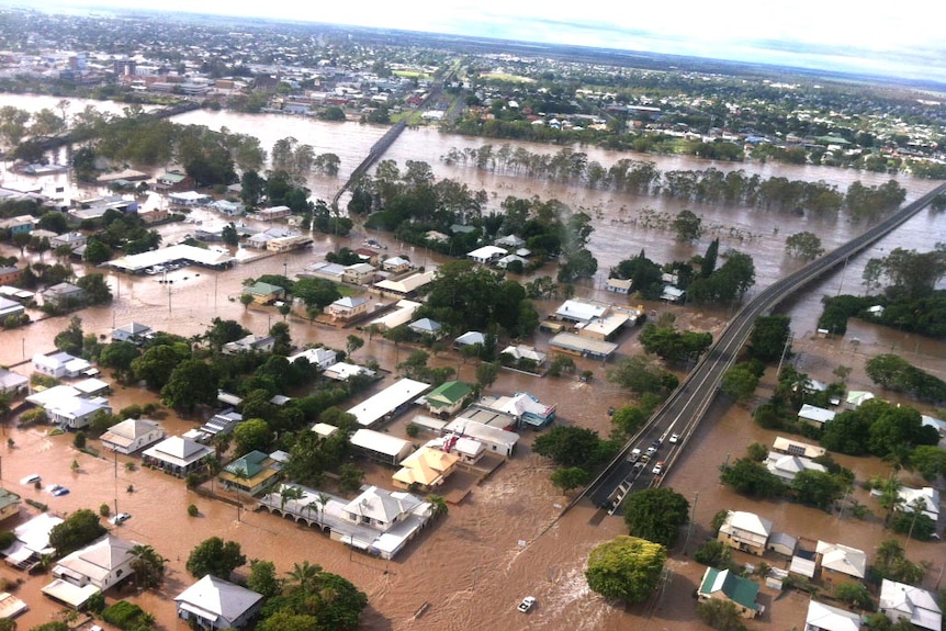 An aerial shot of a rural town totally inundated with muddy floodwater.