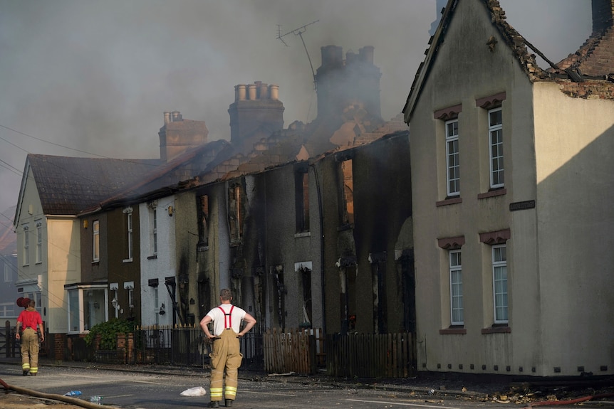 The scene of a blaze in the village of Wennington with firefighters watching on