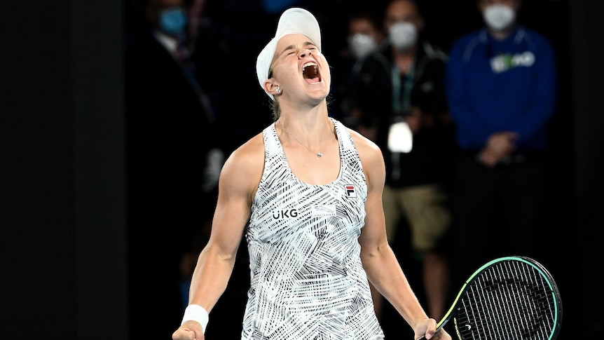 Ash Barty screams with both fists clenched, one around a tennis racket, after winning the Australian Open final.