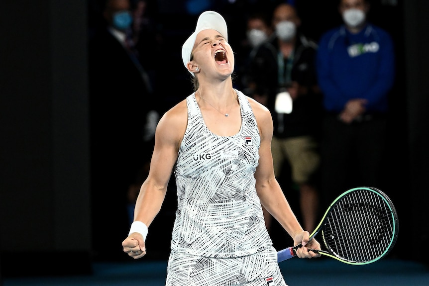 Ash Barty screams with both fists clenched, one around a tennis racket, after winning the Australian Open final.