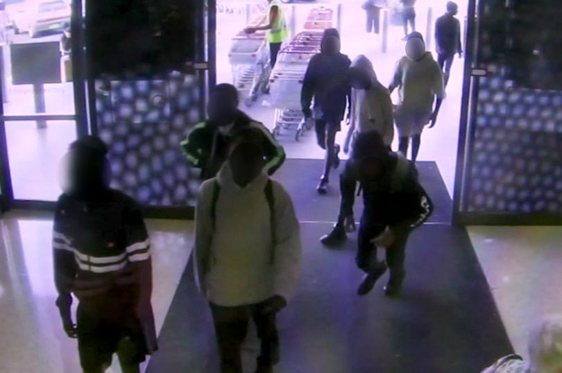 Several young men enter a shopping centre.