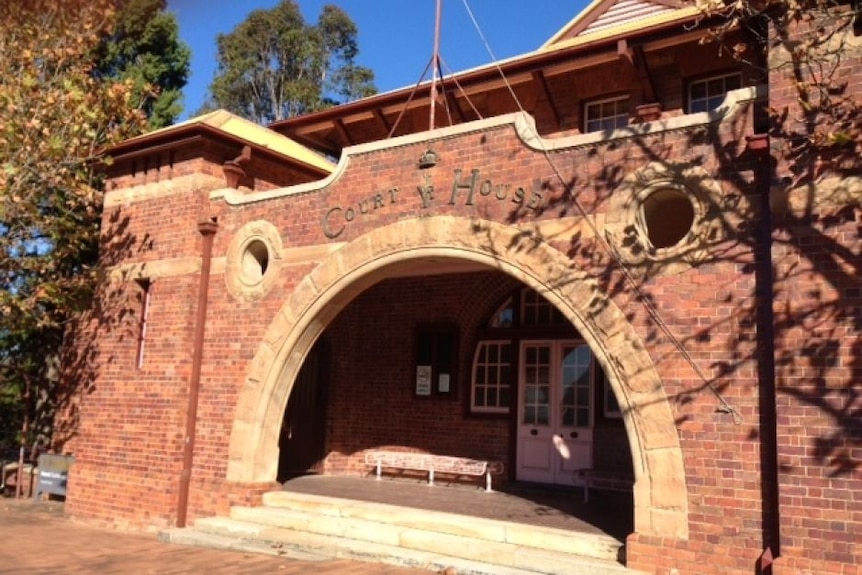 the exterior of a brick courthouse with an arched entrance