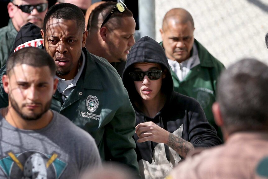Justin Bieber walks to a car after being released from a Miami jail.